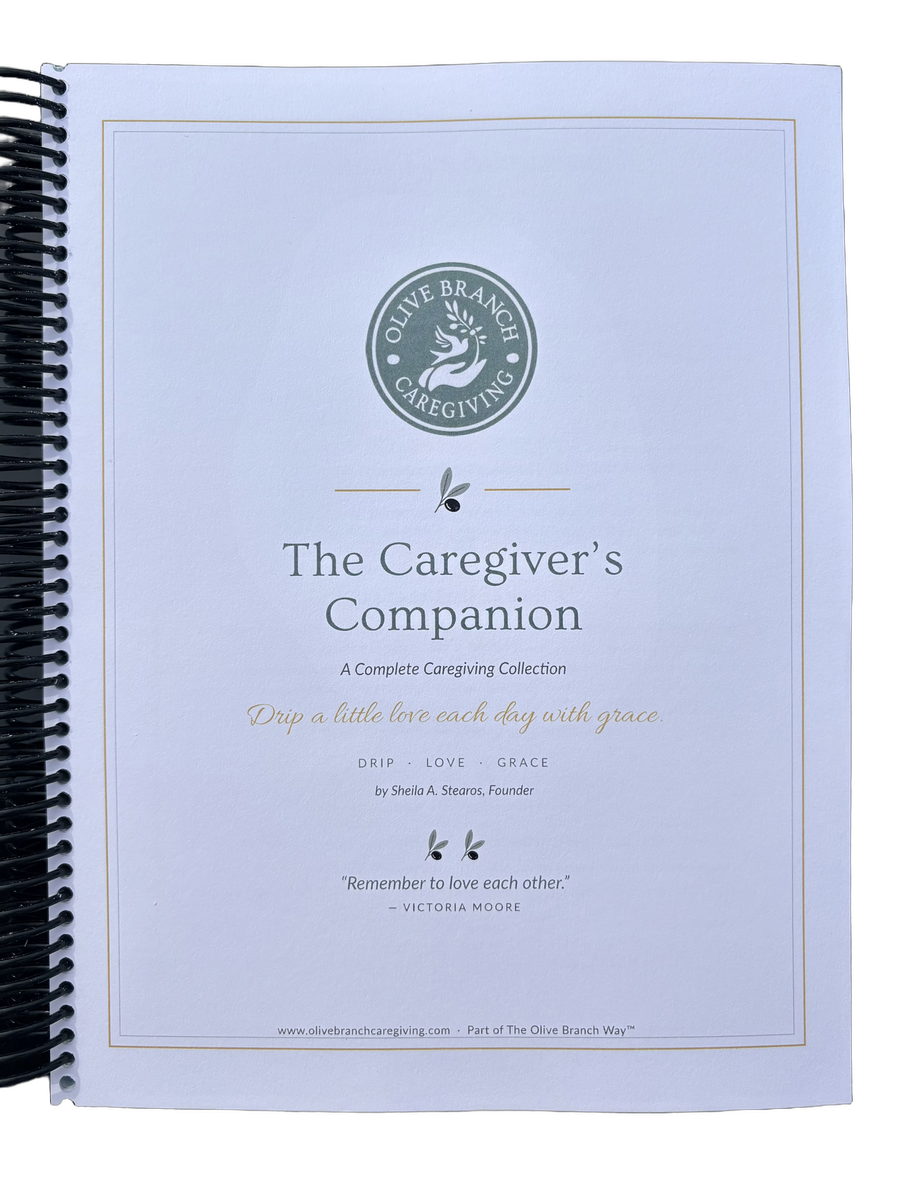 The printed, spiral-bound Caregiver’s Companion binder resting on a table